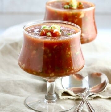 Two clear glass bowls of gazpacho.