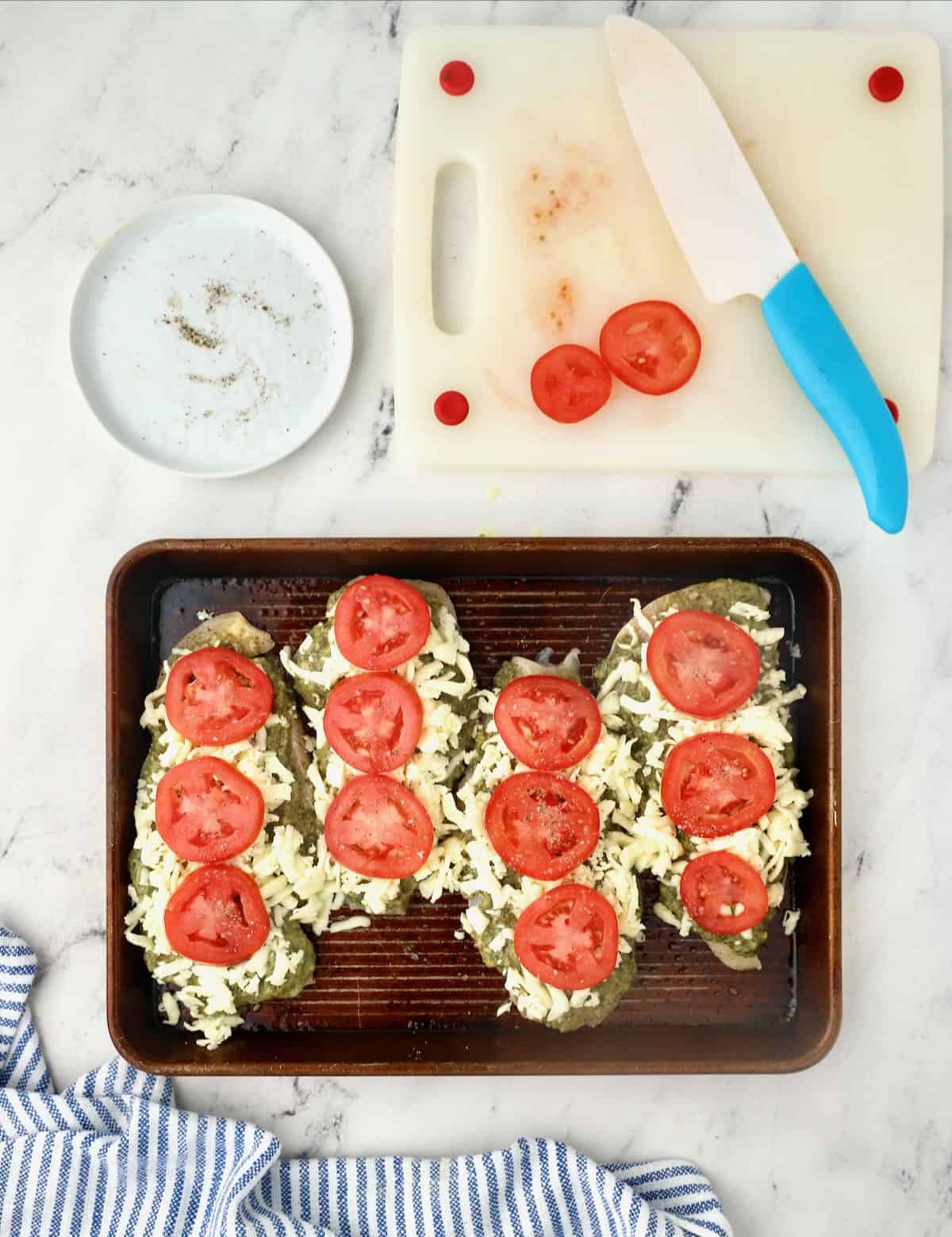 Four chicken breasts topped with pesto, cheese and tomatoes. 