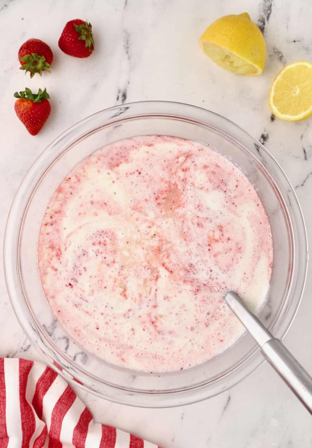Strawberry puree and buttermilk in a large glass bowl. 