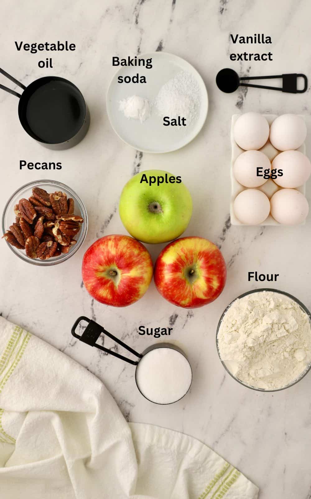 Ingredients for an apple cake including apples, pecans, and flour. 