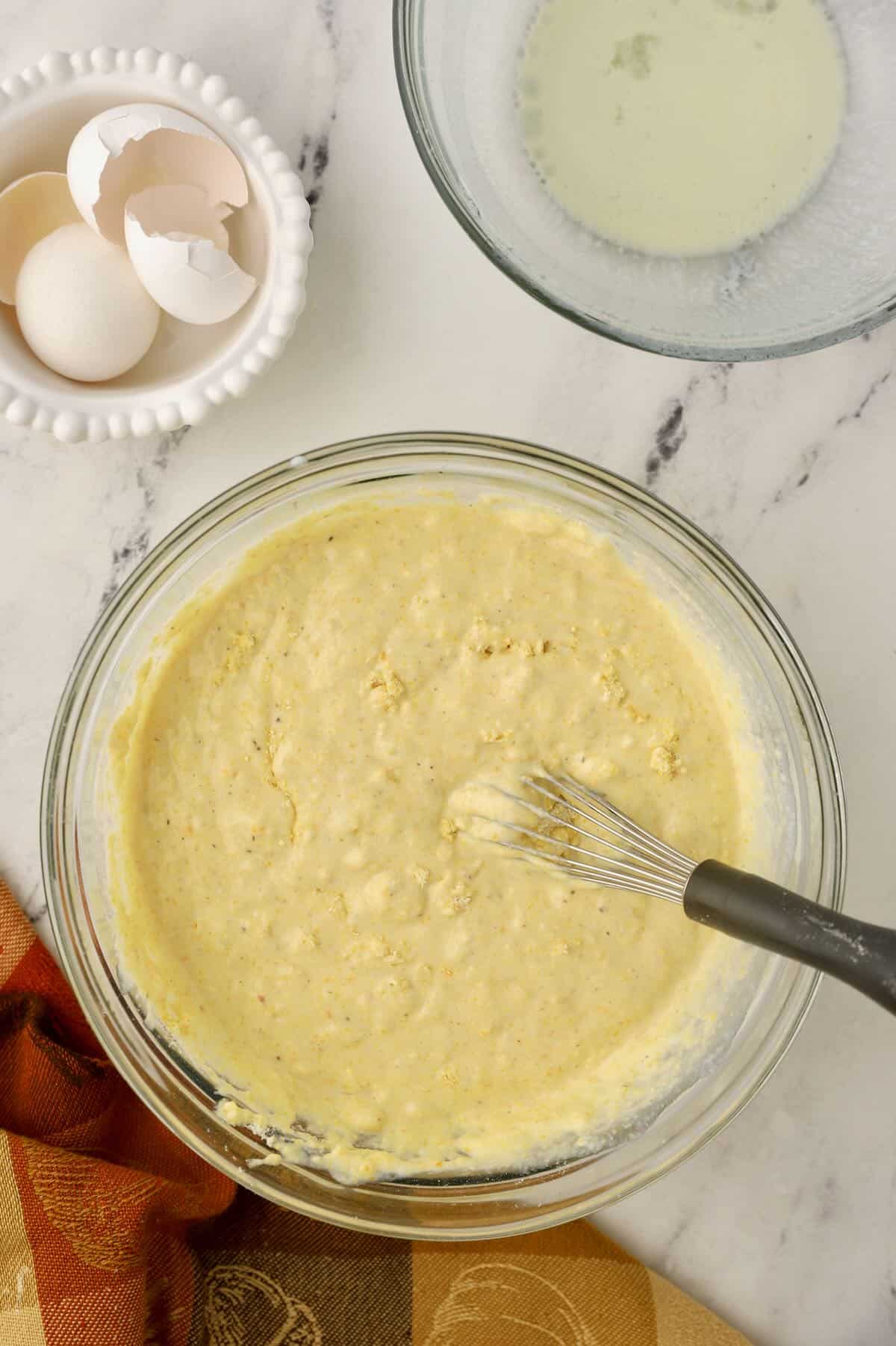 Cornbread batter in a clear glass bowl. 