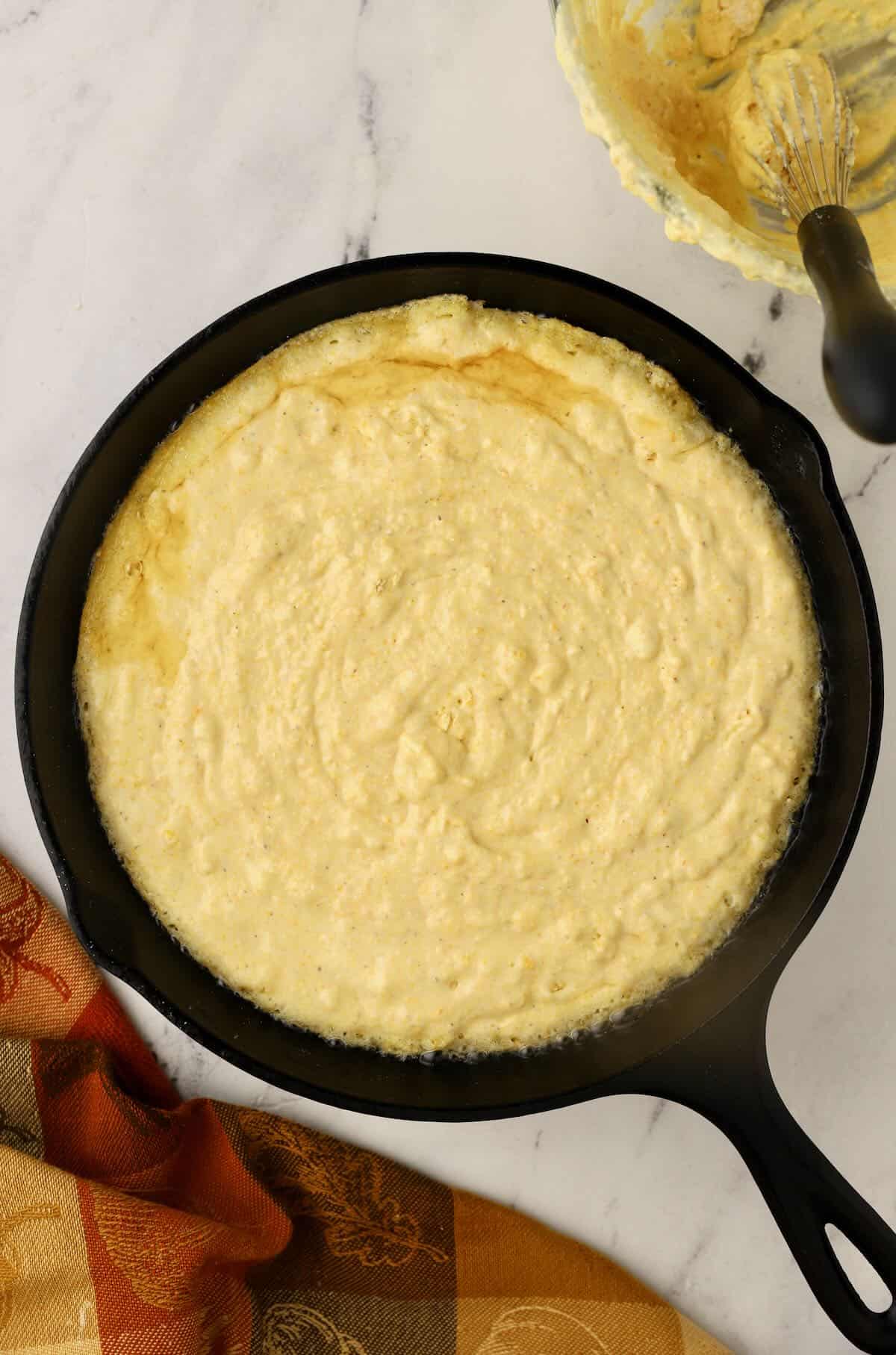 Cornbread batter in a cast iron skillet. 