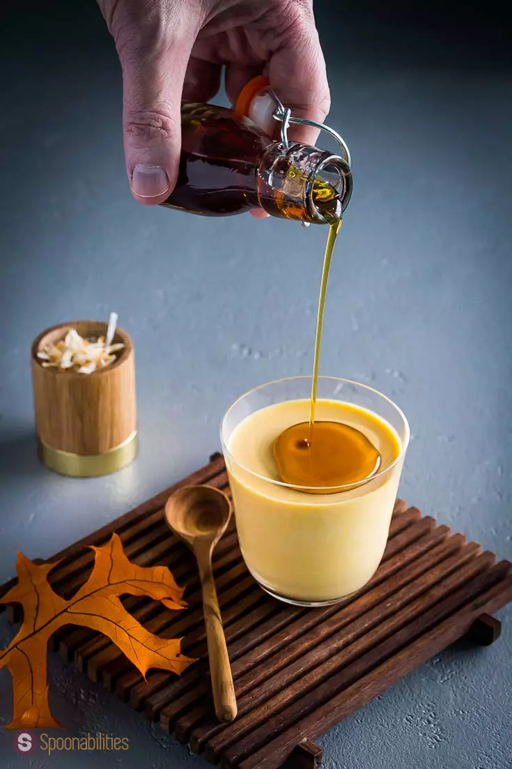 Pouring maple syrup over pumpkin panna cotta 