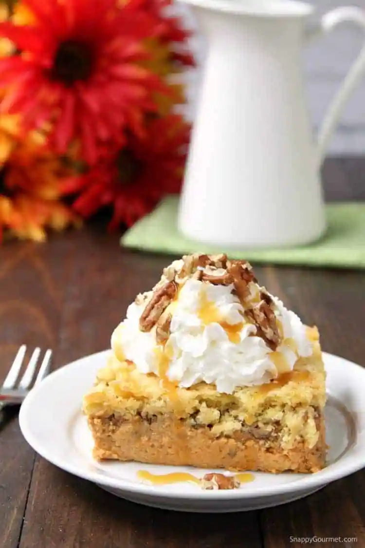 A piece of pumpkin dump cake topped with whipped cream. 