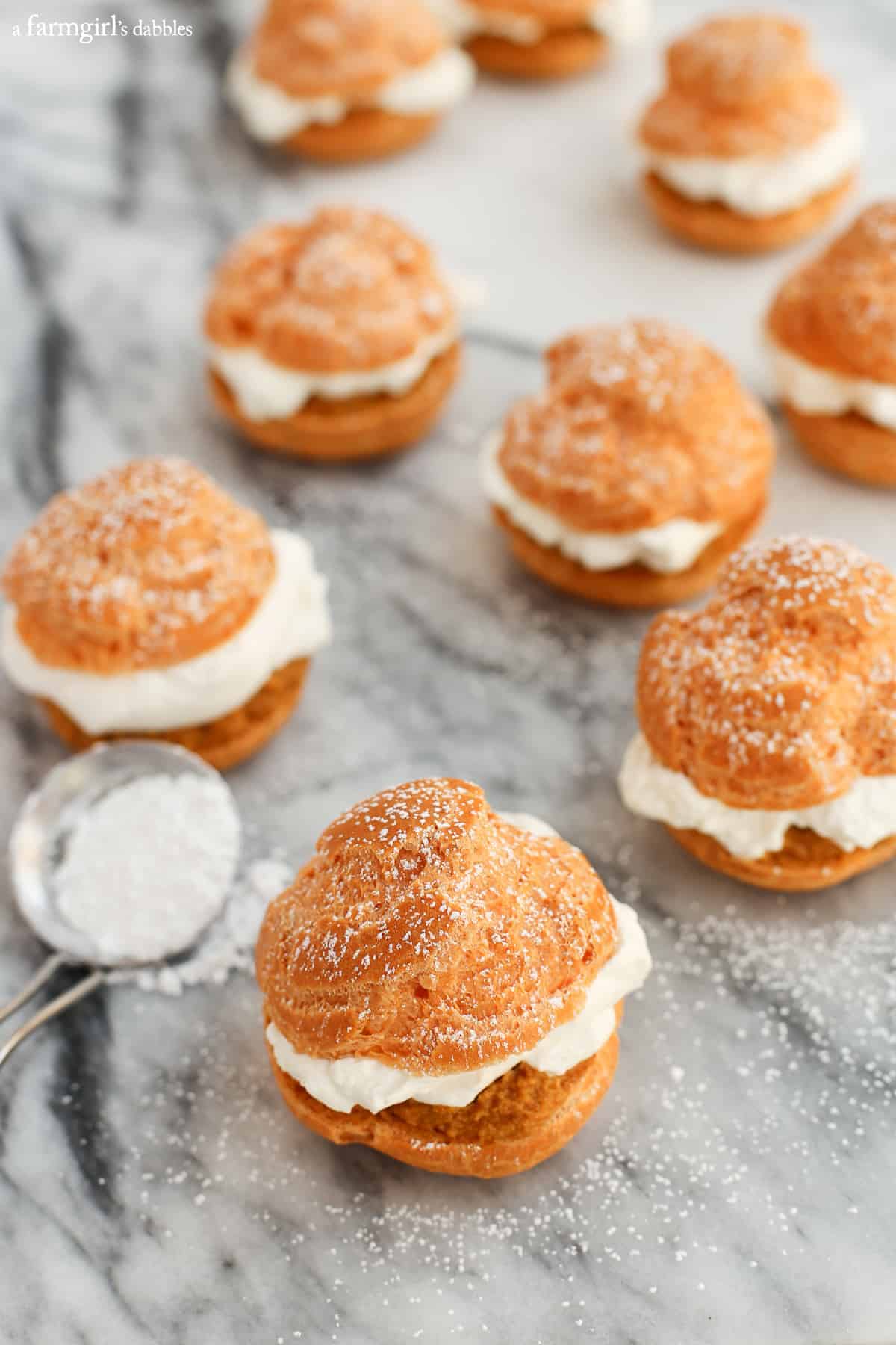 Pumpkin pie cream puffs on a baking sheet. 