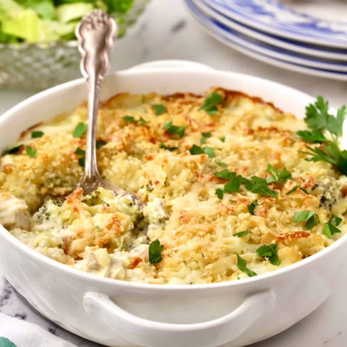 A round baking dish full of baked chicken divan.