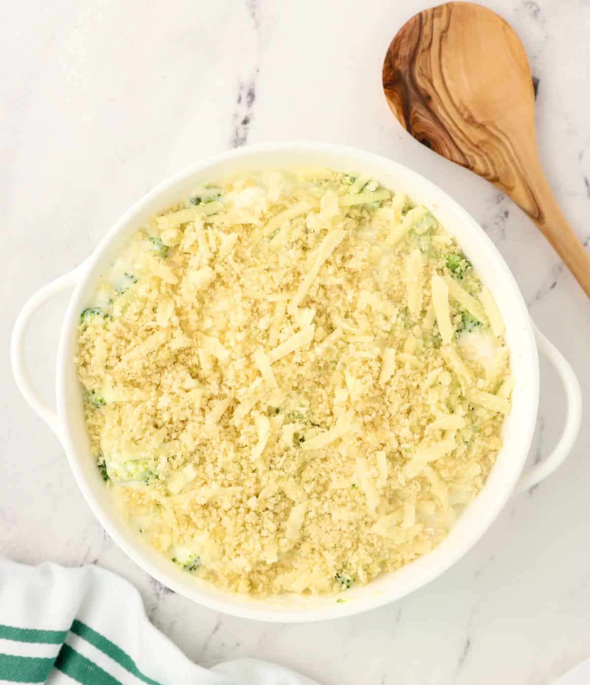 An unbaked chicken casserole topped with panko in a baking dish. 