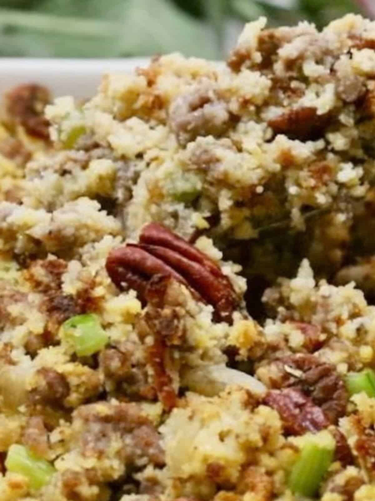Dressing made with cornbread, sausage, and pecans in a baking dish.