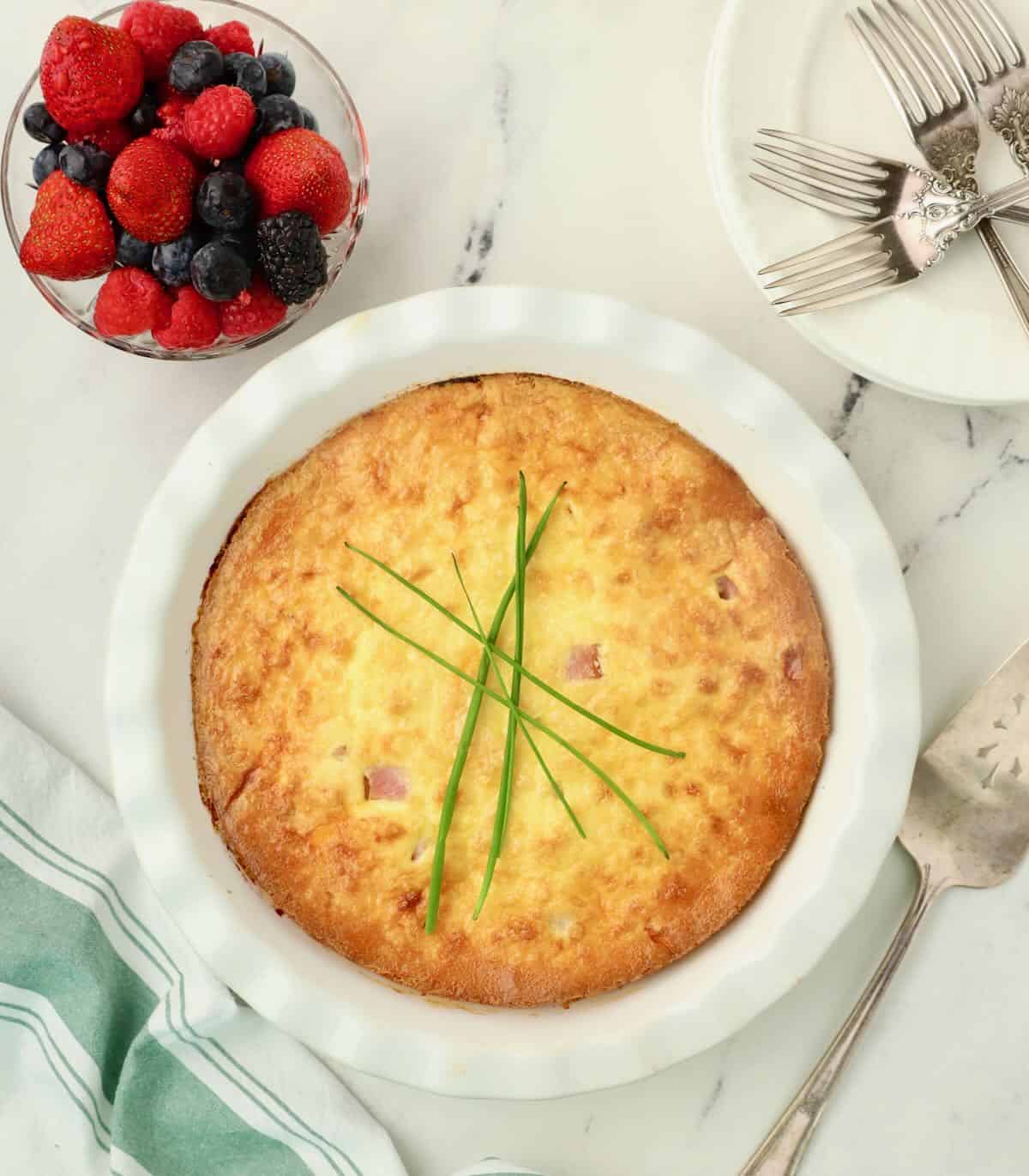 A whole quiche garnished with chives. 