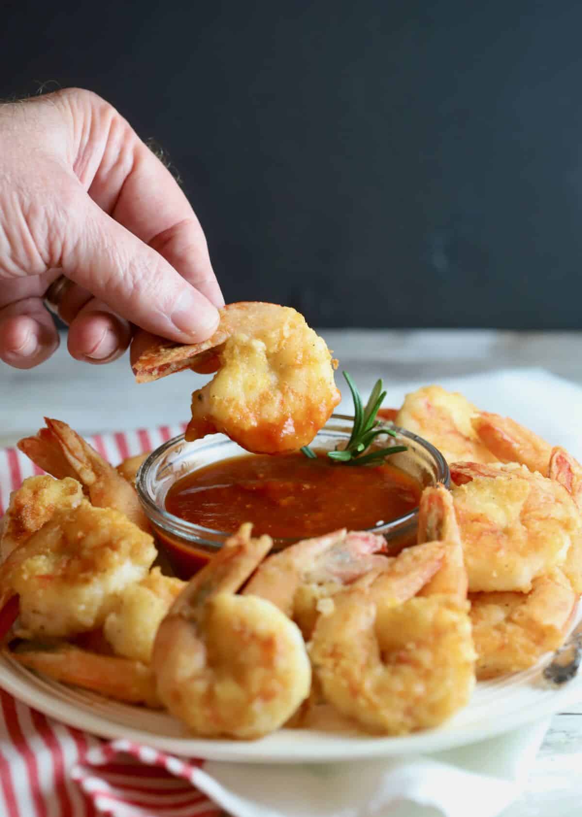 Fried shrimp on a plate with cocktail sauce. 