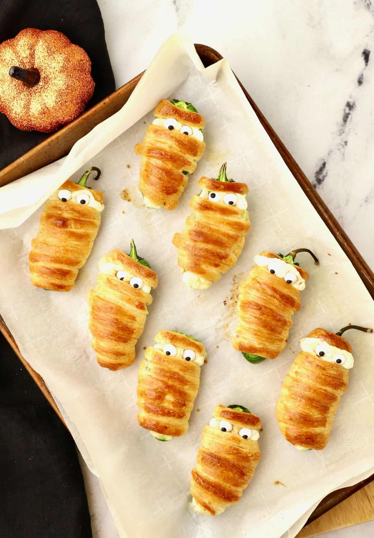 A baking sheet with baked stuffed jalapeno poppers. 