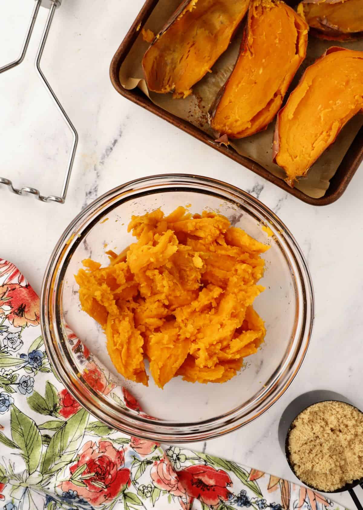 Baked sweet potatoes cut in half with the flesh scooped out. 