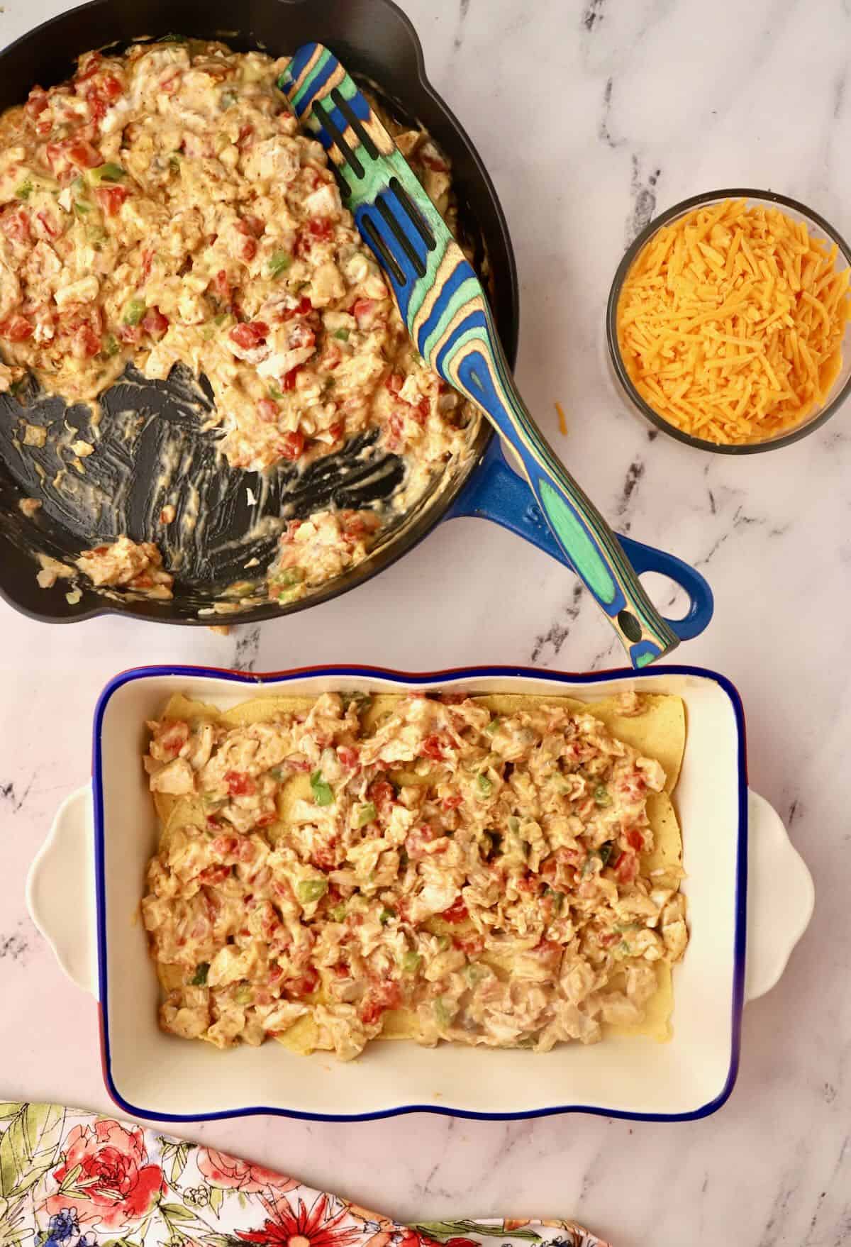 Layering a chicken casserole with a chicken mixture and corn tortillas. 