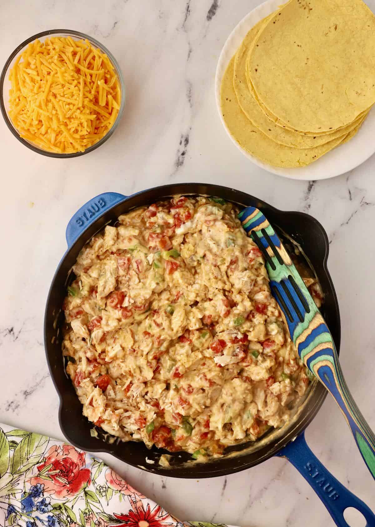 A skillet with cooked chicken and other ingredients for a casserole. 