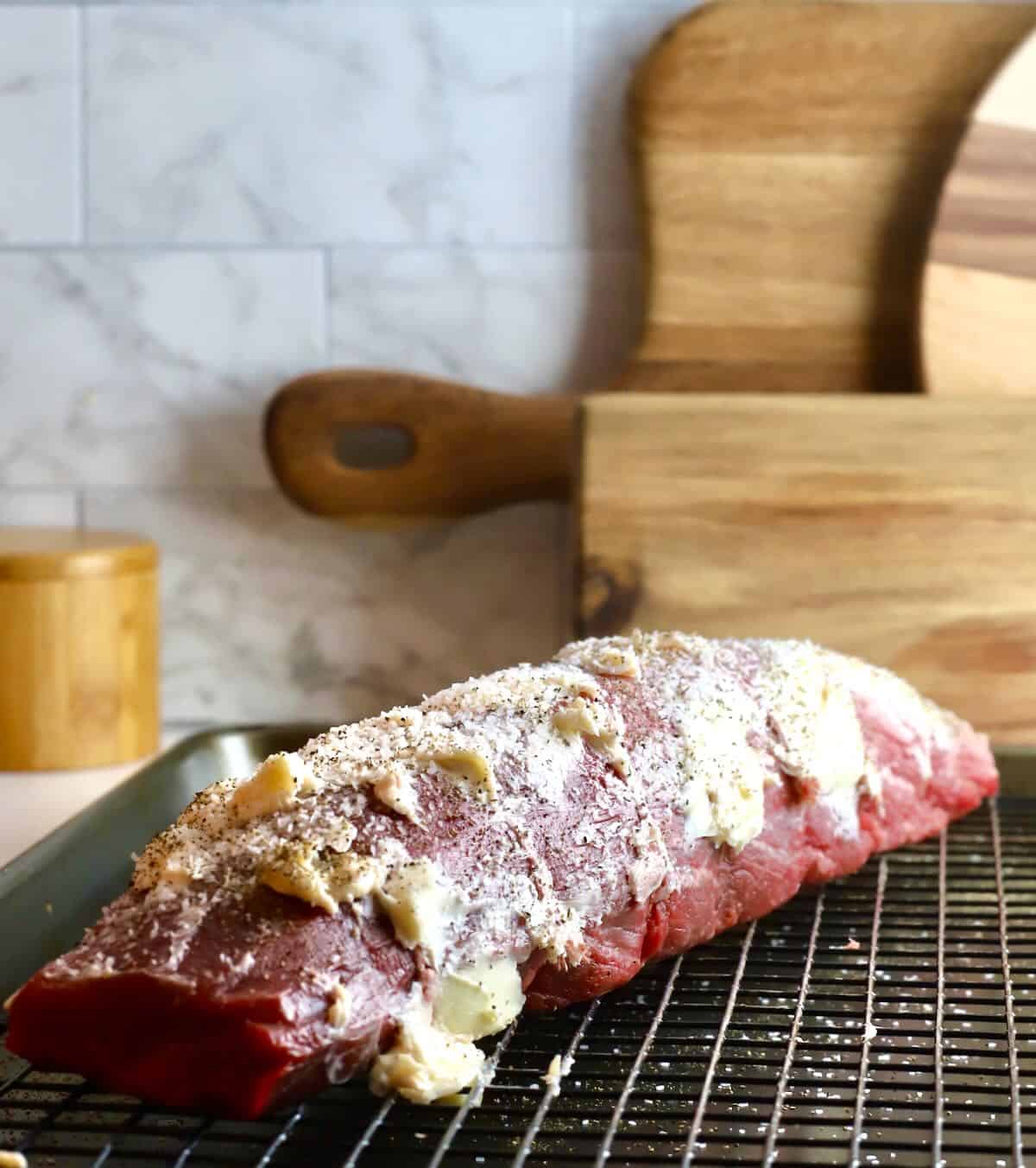 A beef roast covered with butter and seasoned with salt and pepper. 