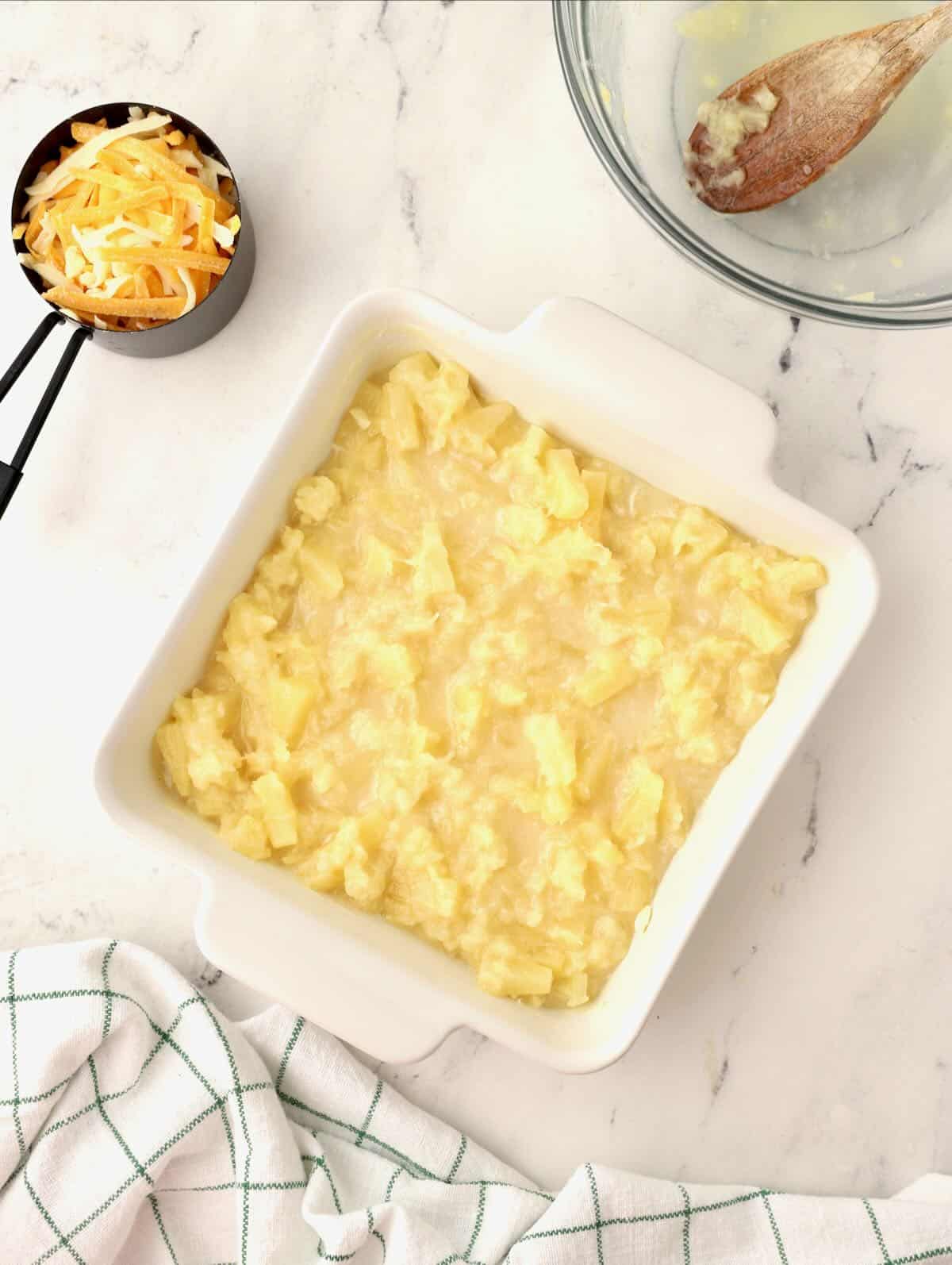 Pineapple mixture in a square white baking dish. 