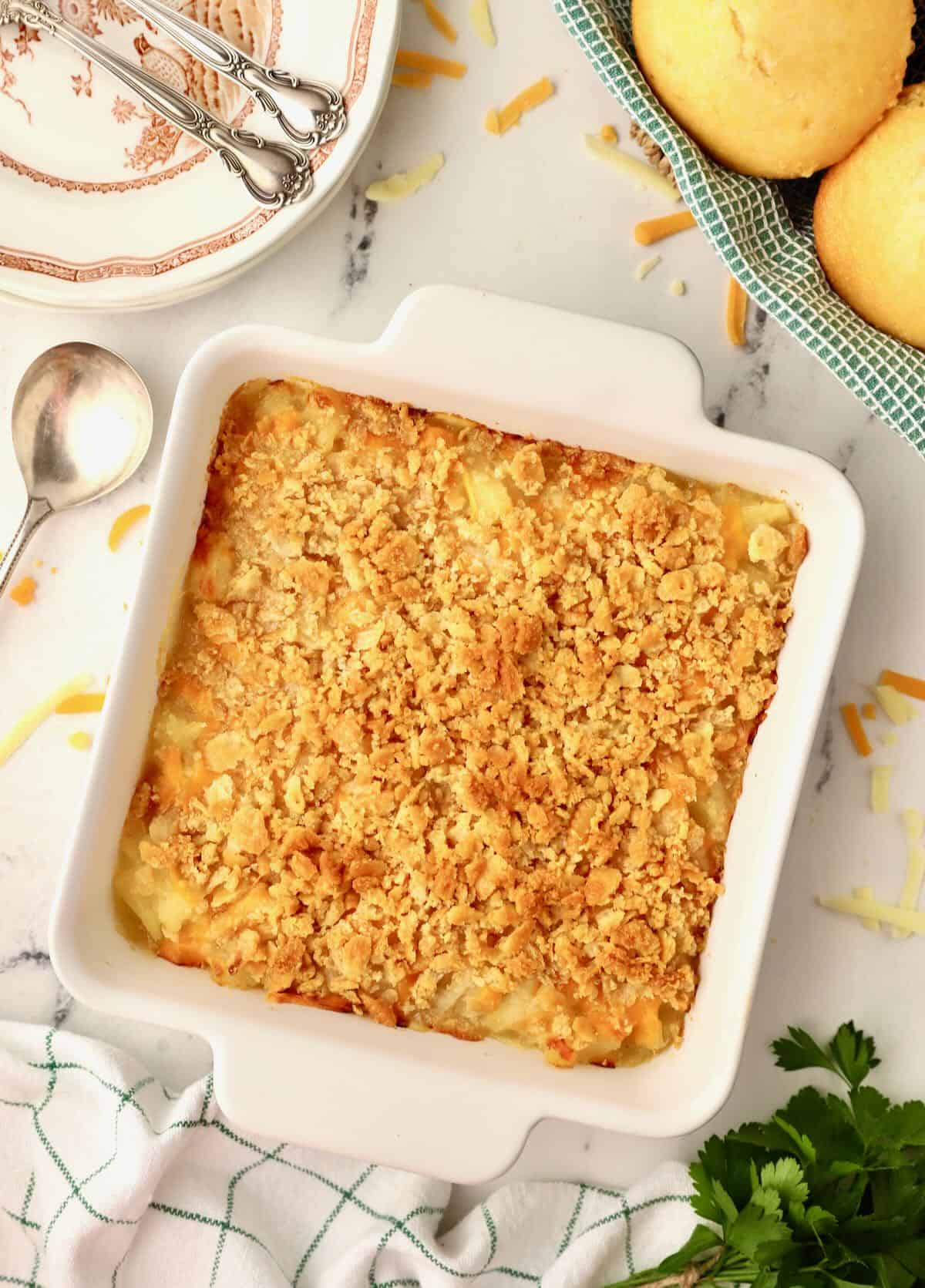 Baked pineapple cheese casserole in a white square baking dish. 