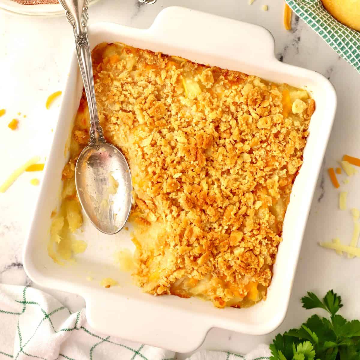 Pineapple cheese casserole topped with crushed Ritz crackers in a white baking dish.