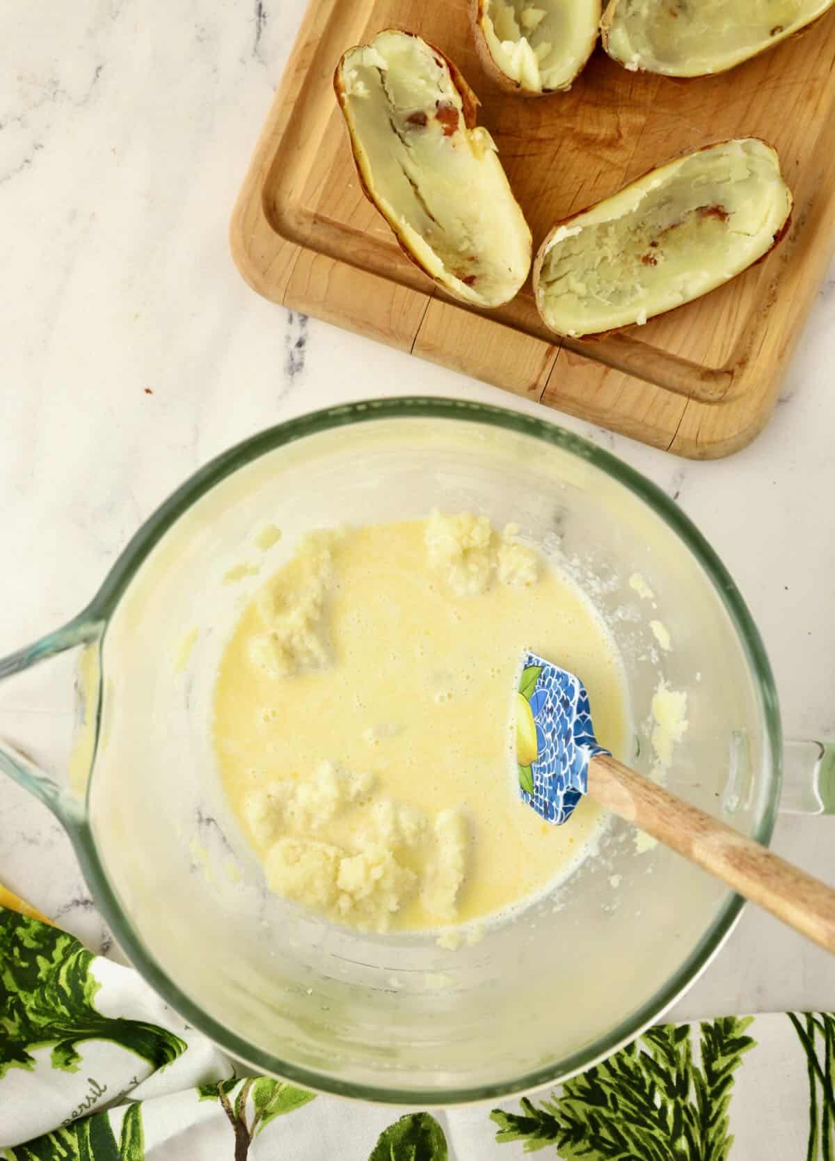 Mashed potatoes in a bowl with cream poured over them.