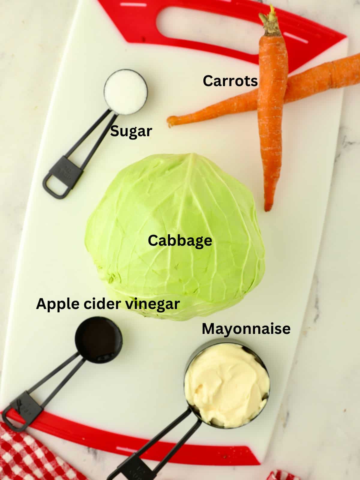 A head of cabbage, two carrots, mayonnaise, vinegar and sugar. 