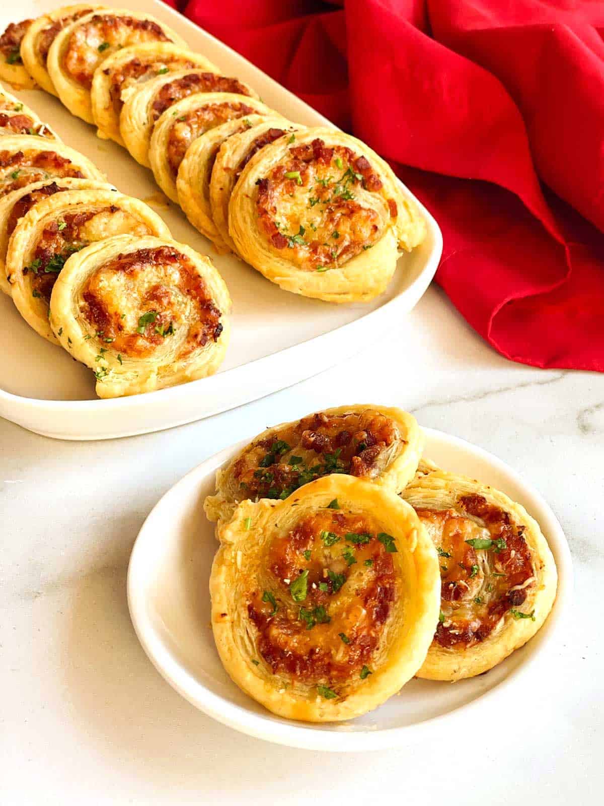 Ham and Cheese Pinwheels made with puff pastry on a white plate. 