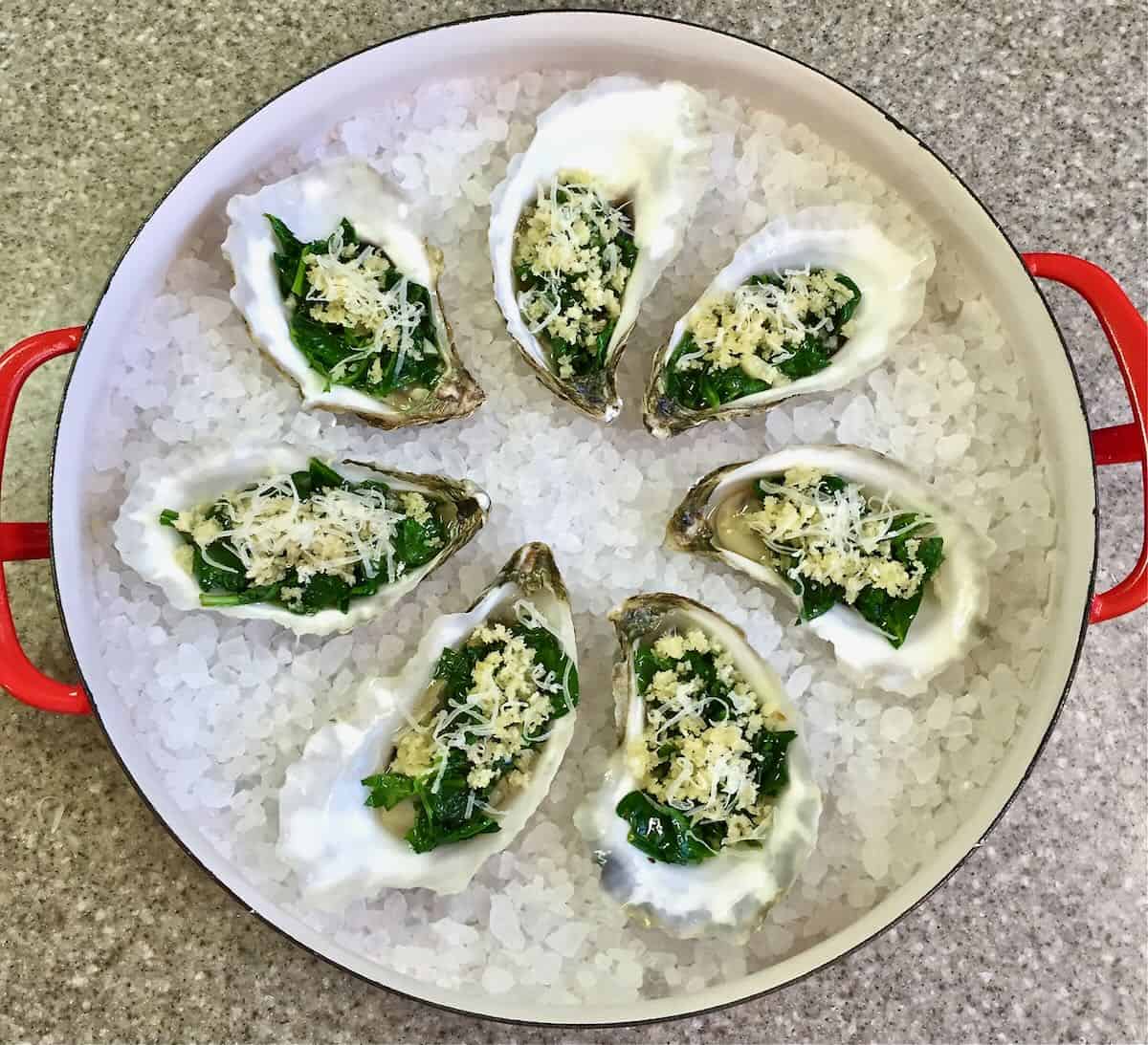 Oysters Rockefeller Casserole (oysters, rockefeller, casserole, blend spinach parmesan cheese, blend spinach parmesan cheese garlic, blend spinach parmesan cheese garlic butter) Oysters Rockefeller on a bed of rock salt ready to bake.