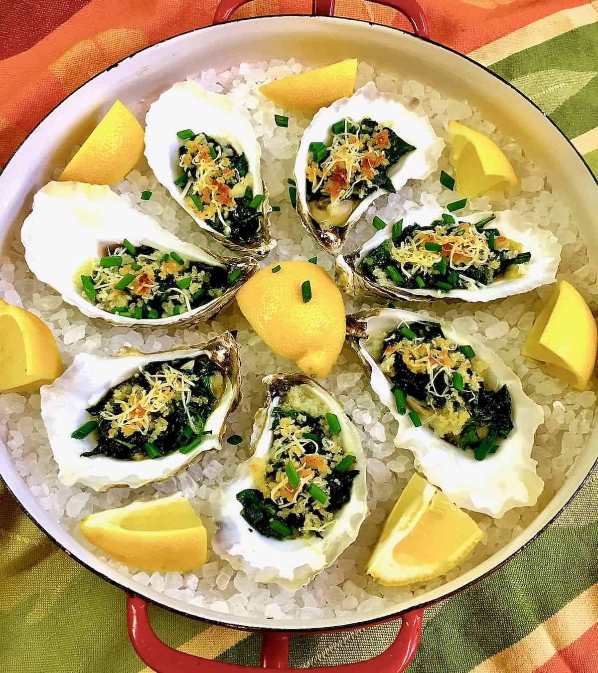 Baked Oysters Rockefeller garnished with lemon wedges ready to serve. 