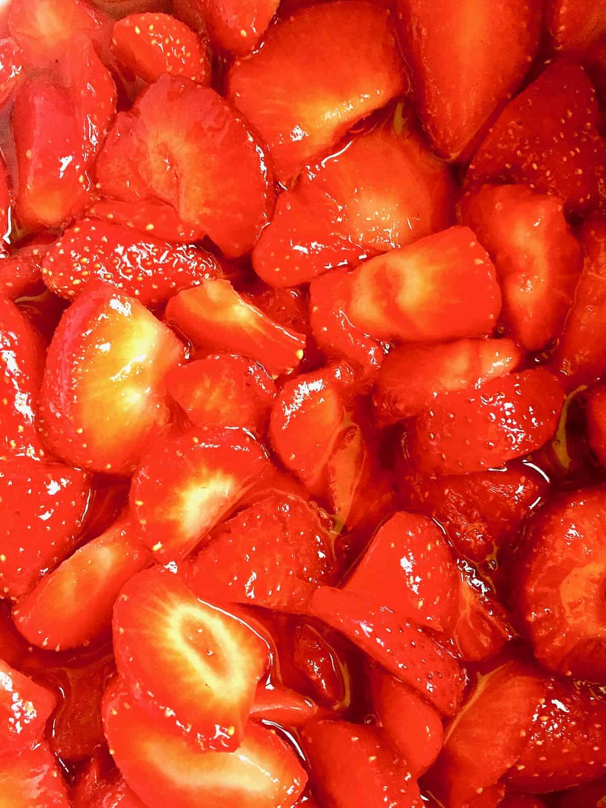 Sliced strawberries that have been macerated covered in juice. 
