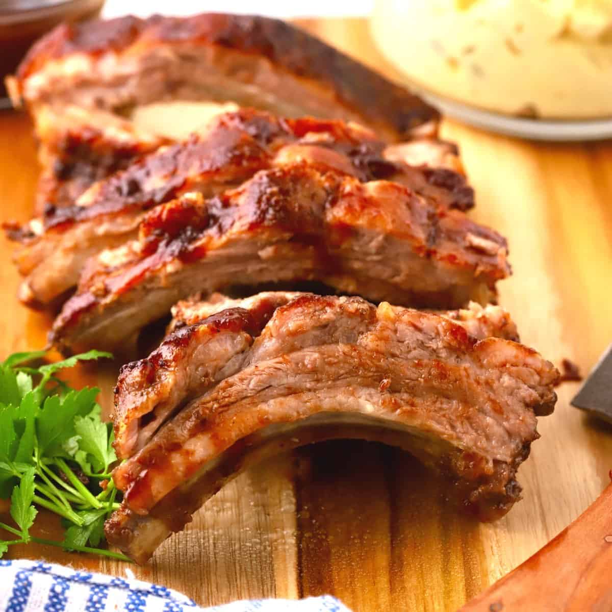 Sliced baby back ribs on a cutting board.