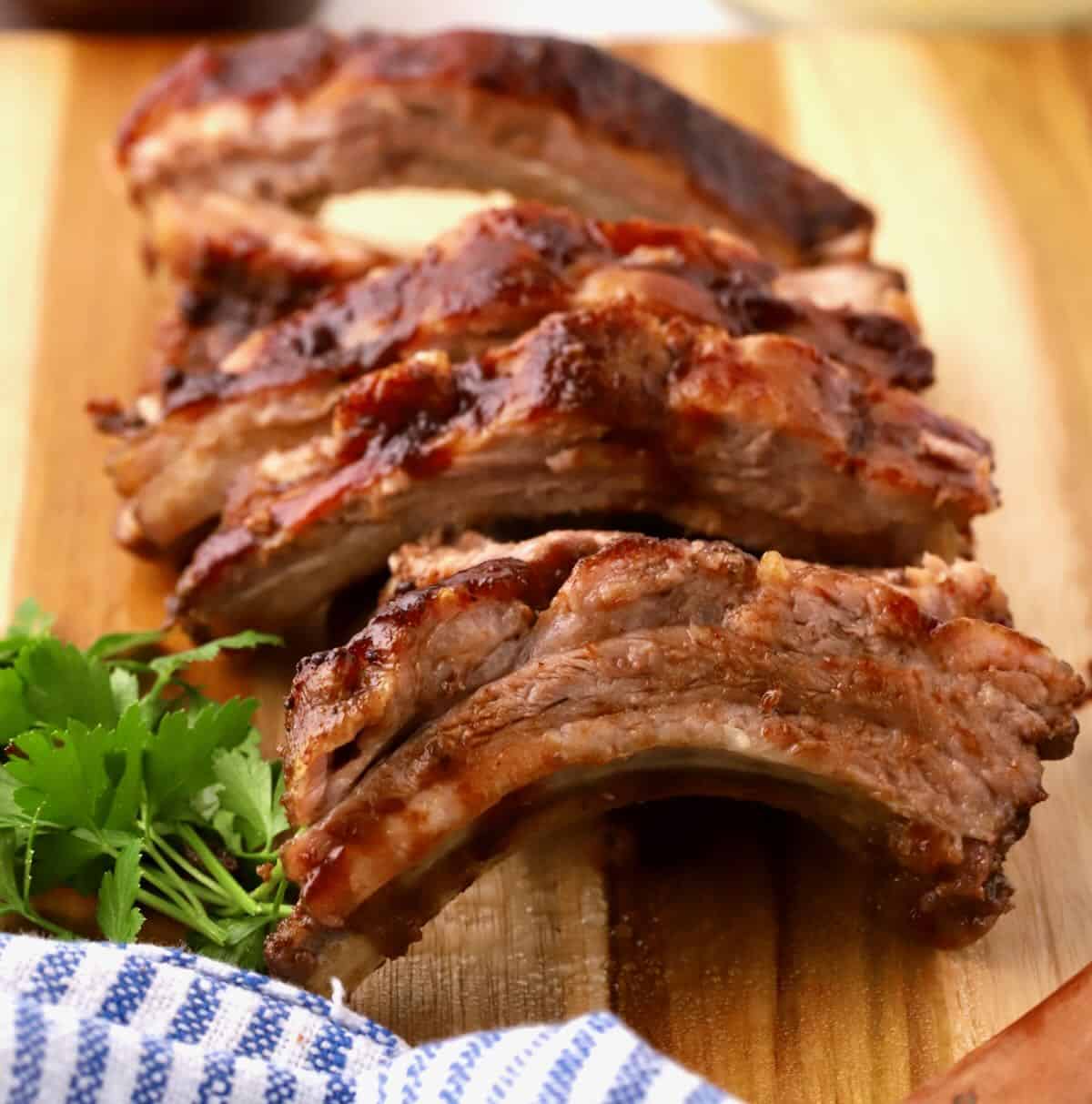 A rack of baby back ribs sliced for serving on a cutting board. 