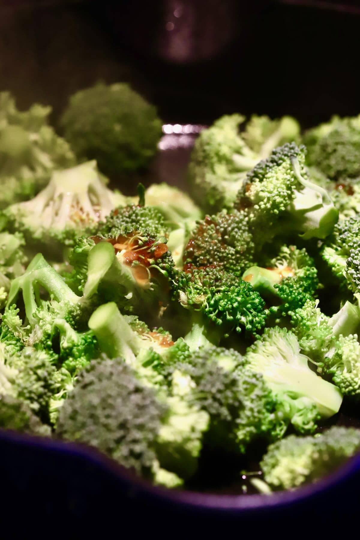 Broccoli florets cooking in a skillet. 