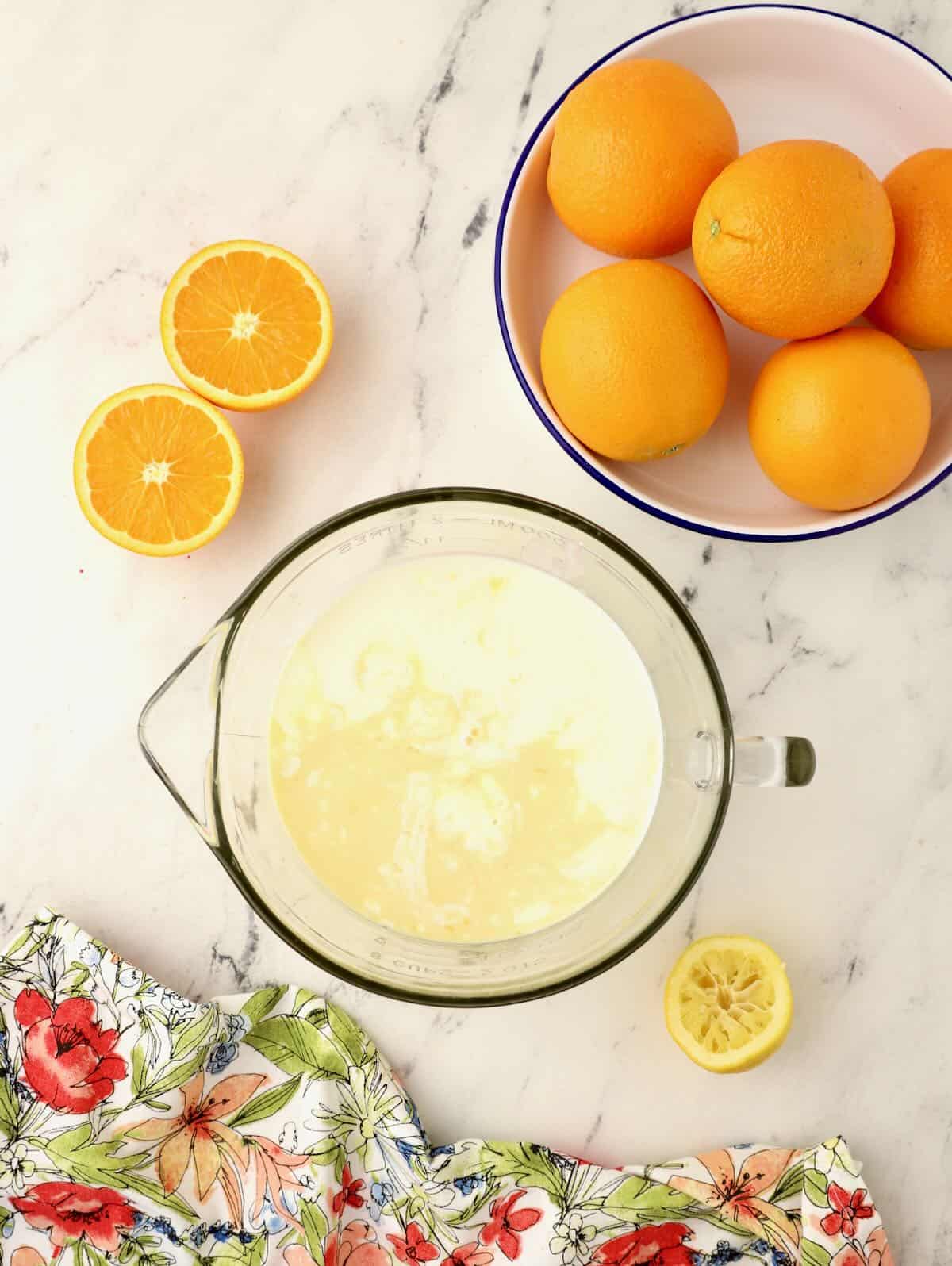Orange juice and buttermilk in a clear glass bowl. 