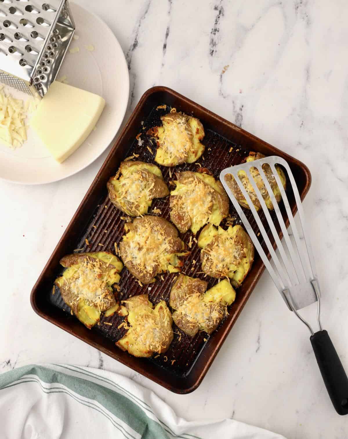 Roasted smashed potatoes on a baking sheet. 