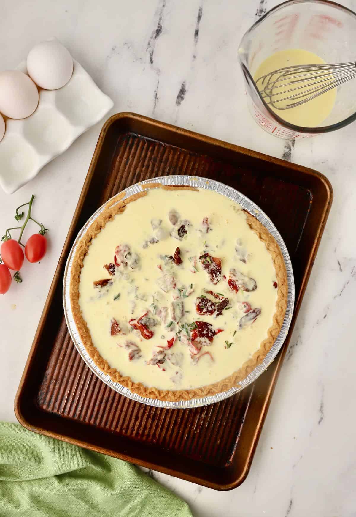 Egg and heavy cream filling in a pie crust ready to bake in the oven. 