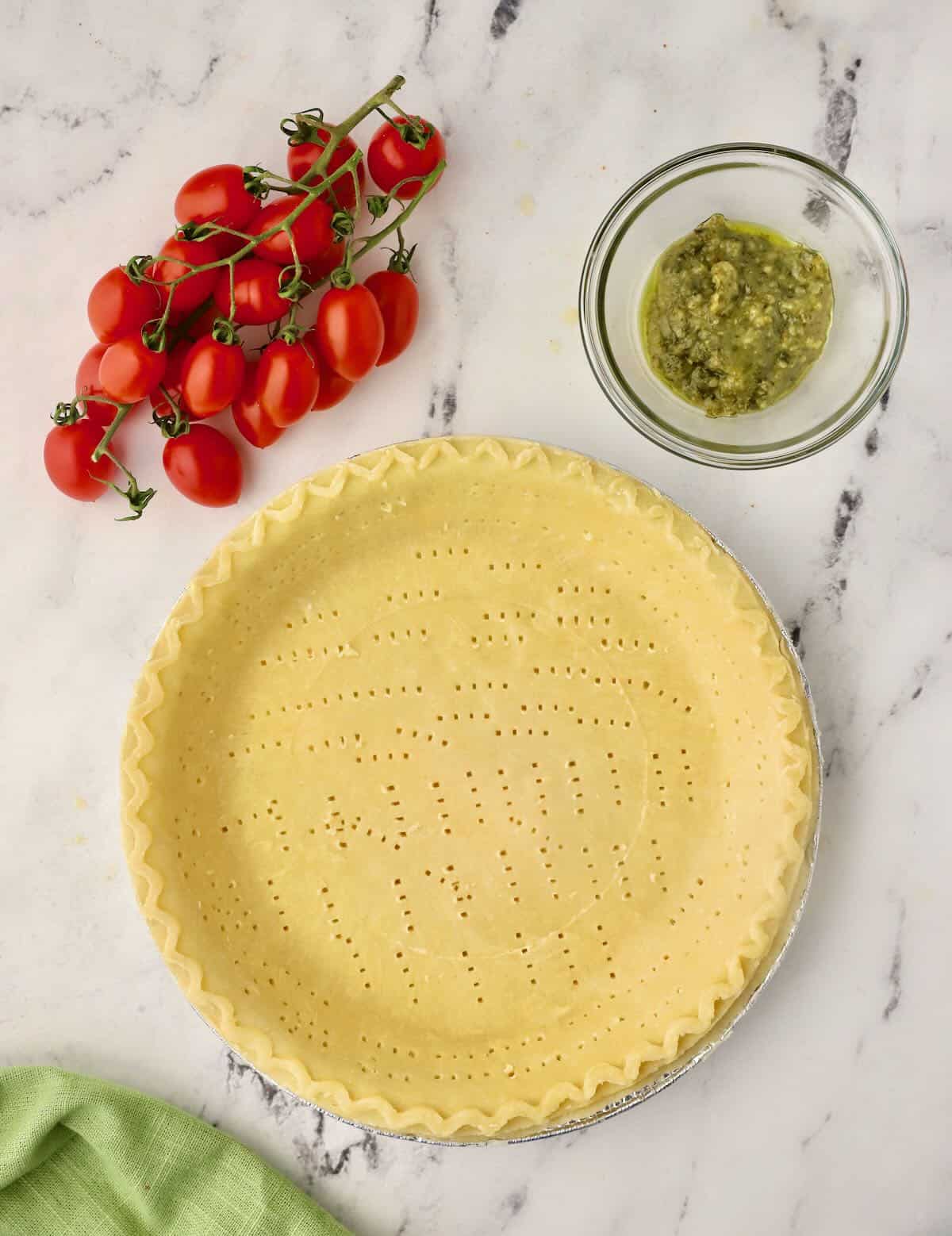 a frozen pie shell pricked with a fork and ready to blind bake in the oven.