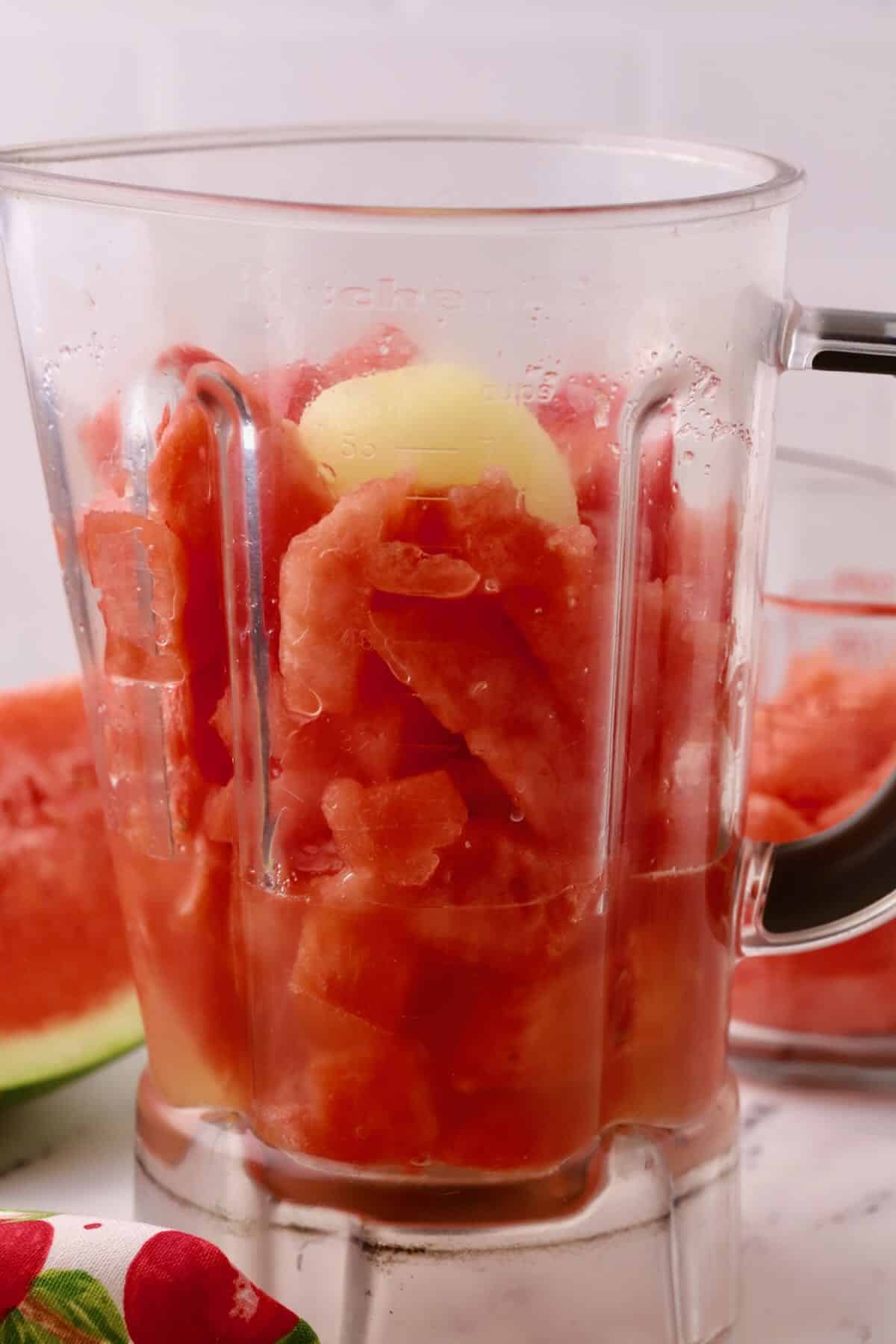 A blender jar with watermelon cubes ready to puree. 