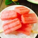 Watermelon popsicles on a plate of ice to keep them cold.
