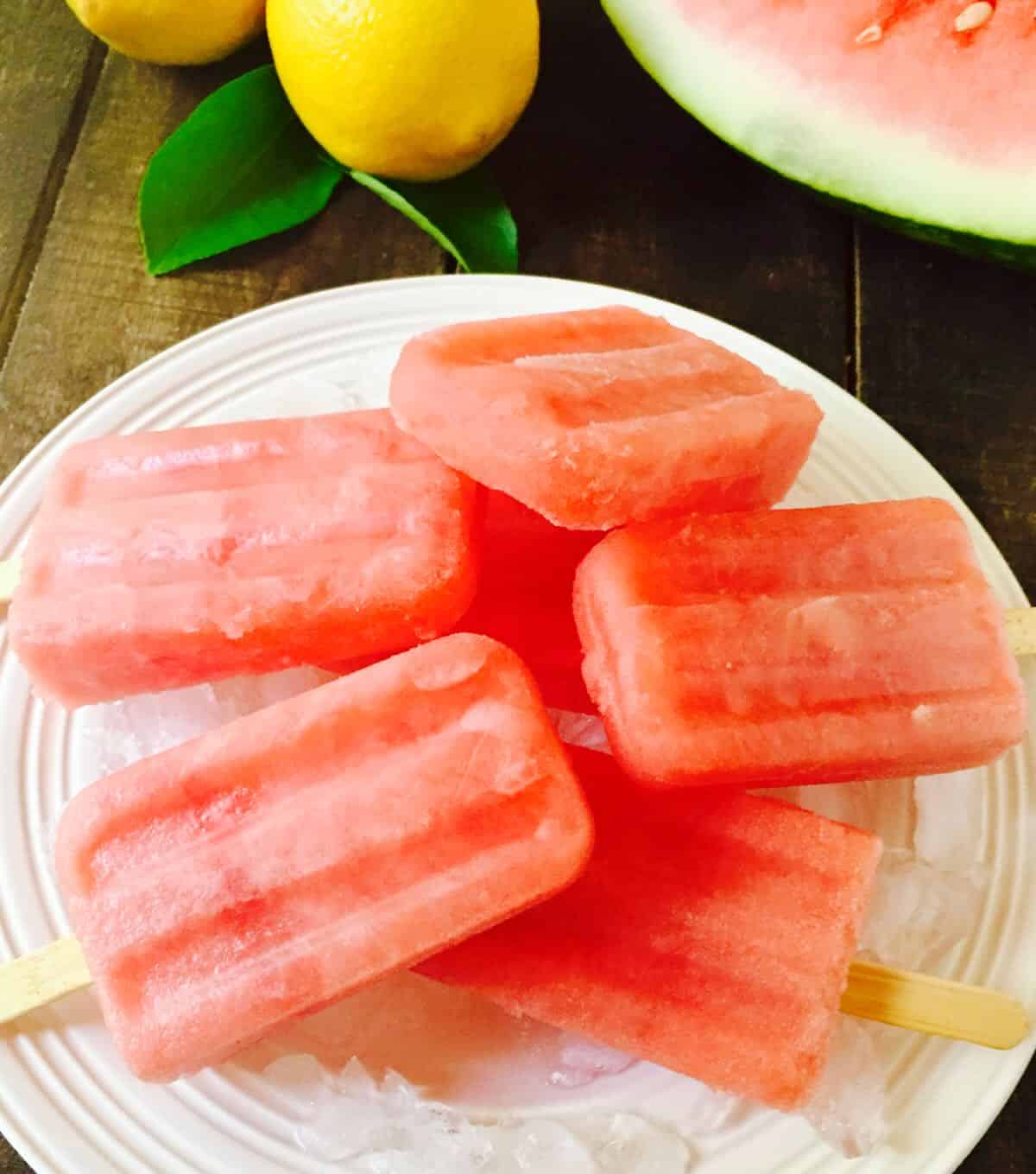 Watermelon popsicles on a plate filled with ice. 