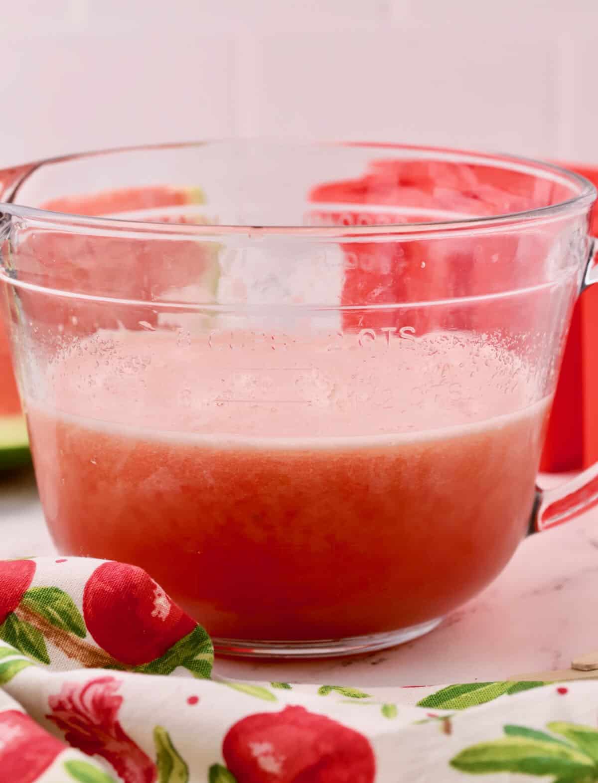 A glass container of watermelon and lemonade that has been pureed. 