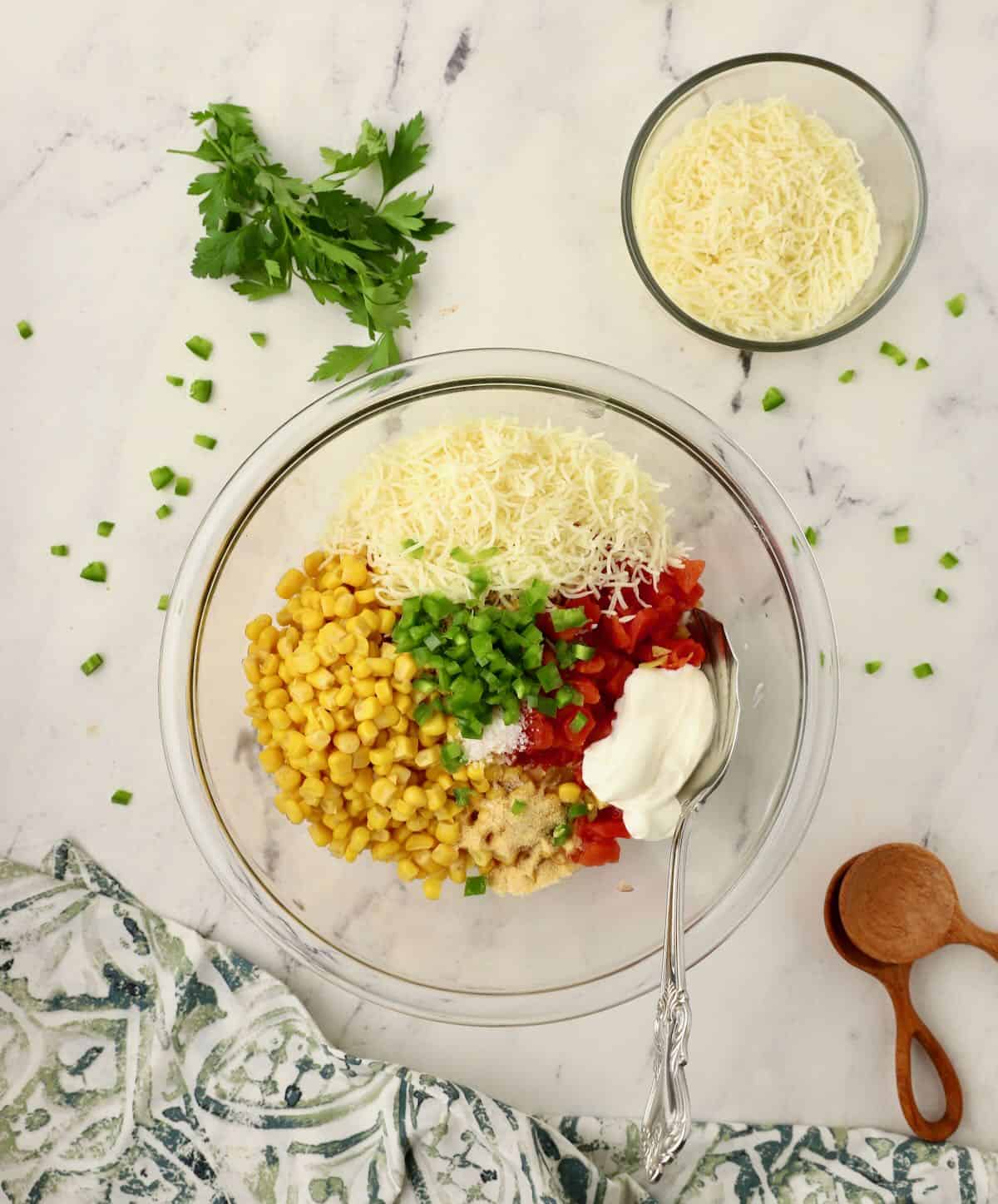 A can of corn, Roten, cheese and chopped jalapenos in a bowl. 