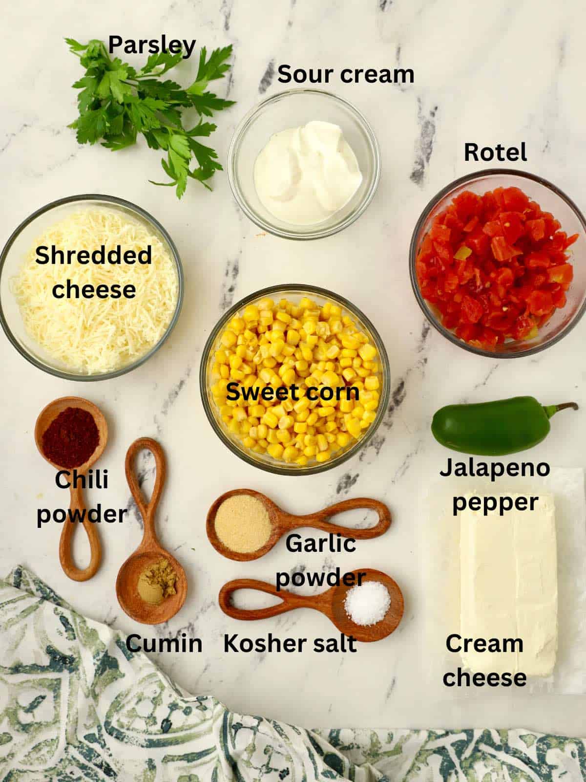 Ingredients to make corn dip including canned corn, cream cheese, and sour cream. 