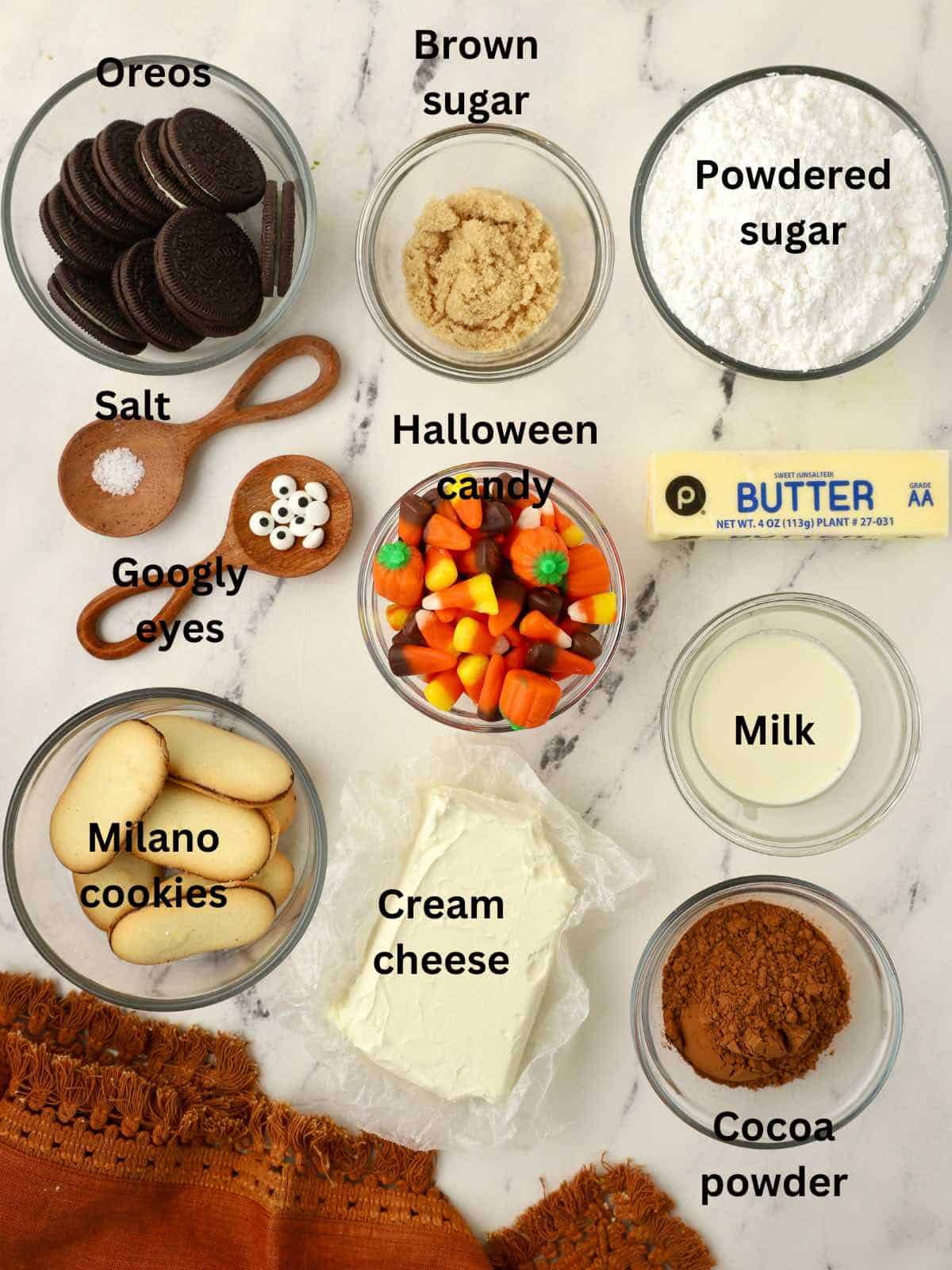 Ingredients to make Chocolate Cheesecake Dip including candy corn, Oreos, cream cheese, and cocoa powder. 