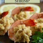 Baked crab stuffed shrimp on a black plate garnished with parsley.