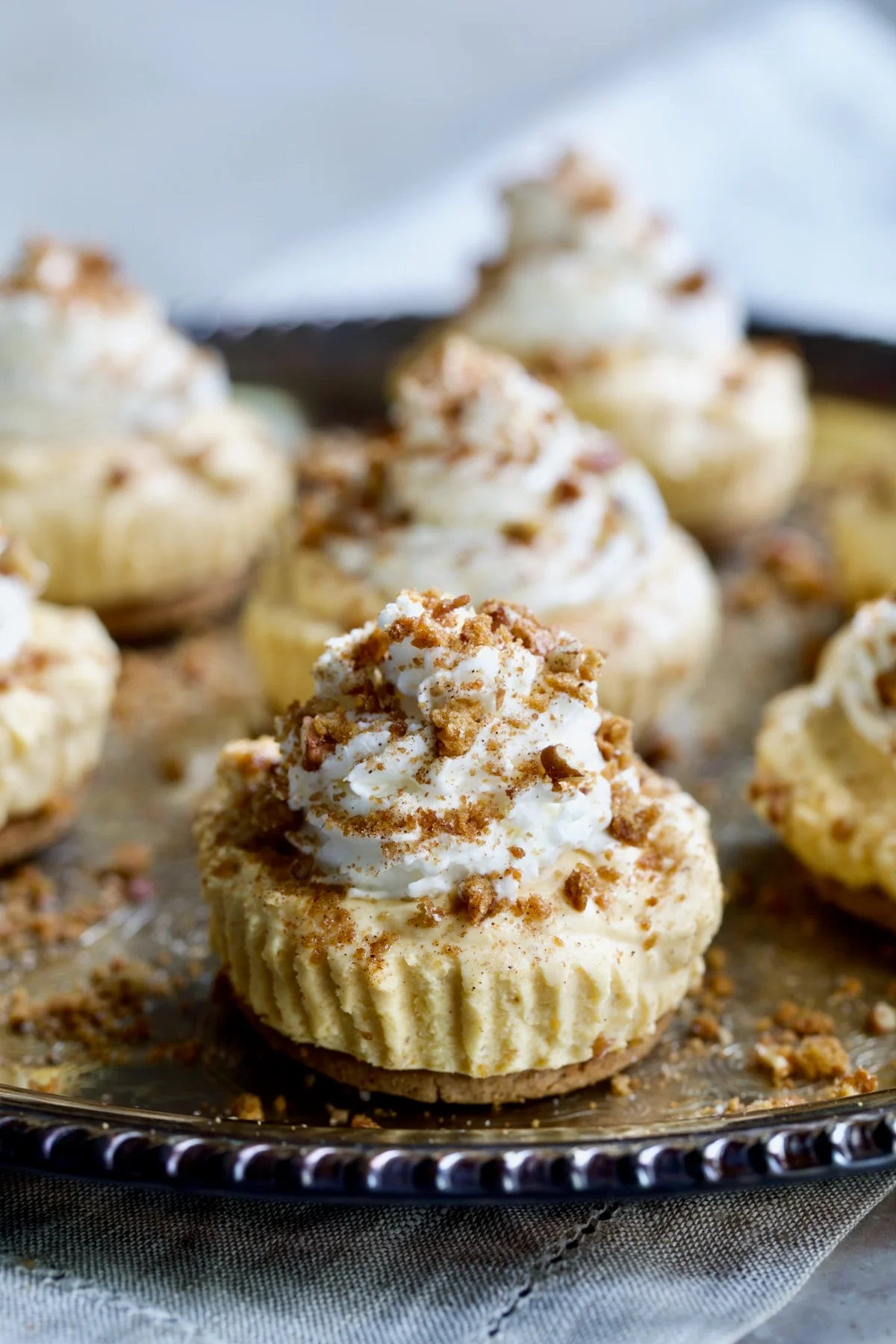No-bake mini pumpkin cheesecakes topped with icing  and chopped pecans. 