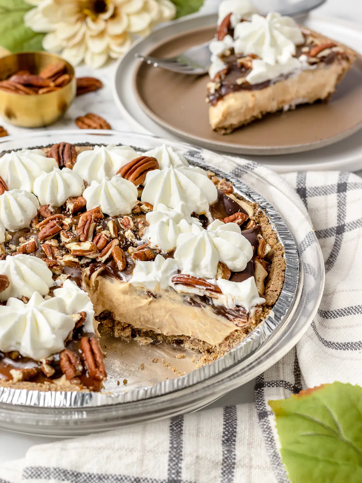 A turtle pie in an aluminum pie plate with a slice cut out. 