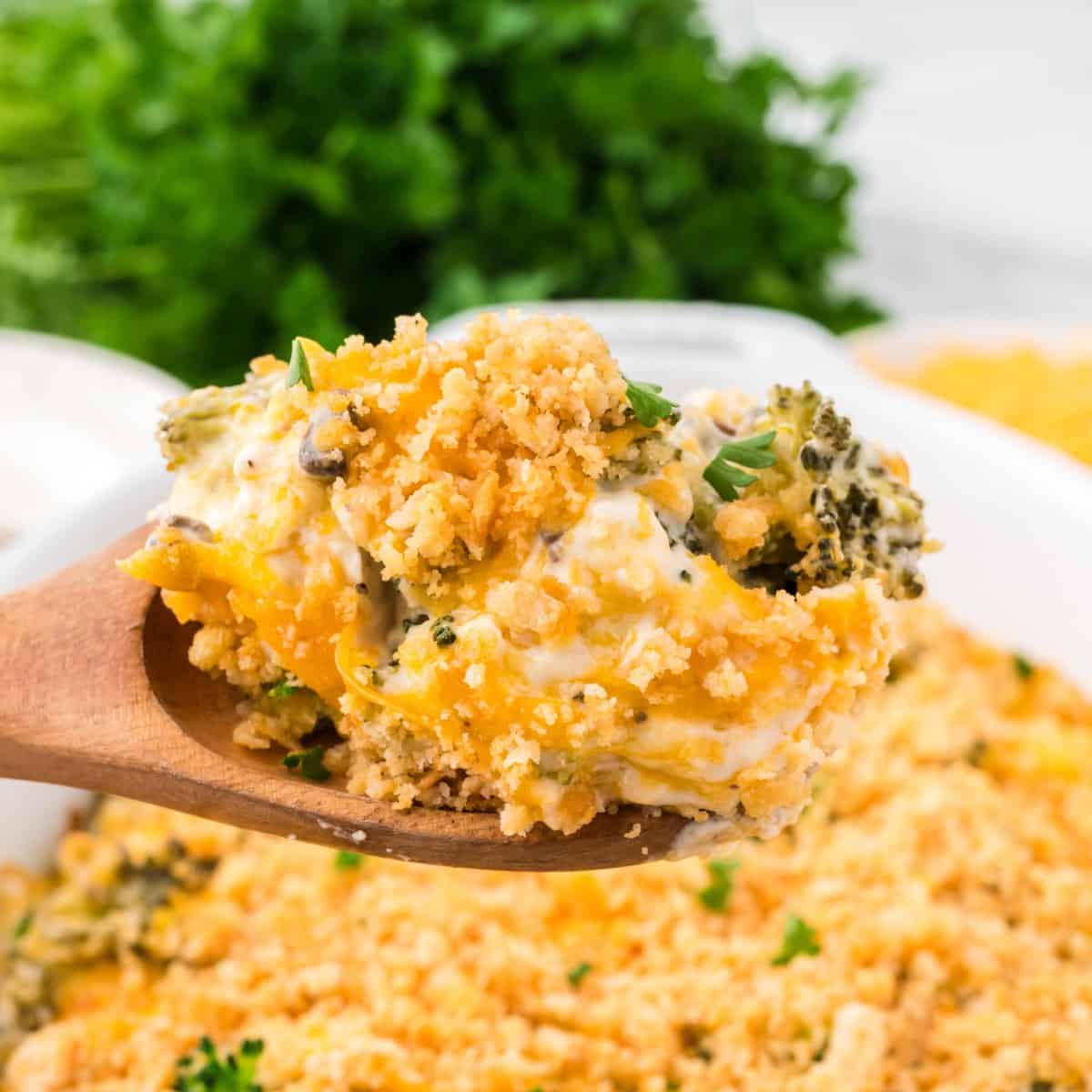 A spoonful of Broccoli Cheese Casserole topped with crushed Ritz crackers and cheese.