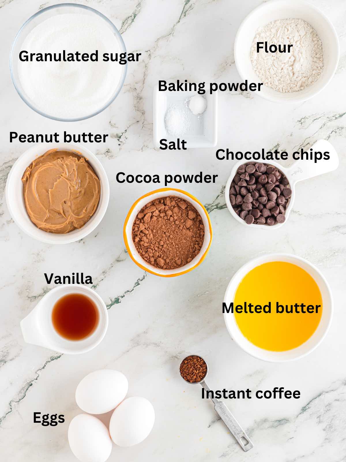 Ingredients for brownies including cocoa powder, eggs, flour and sugar. 