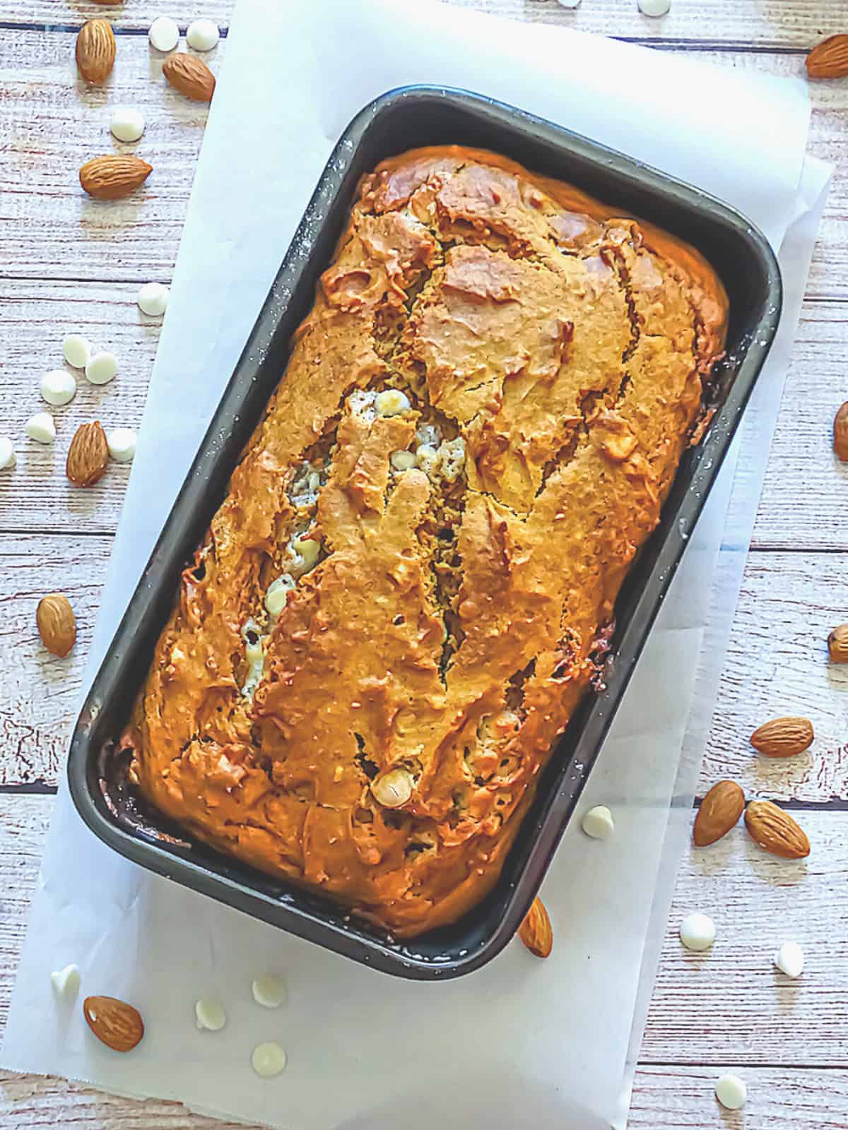 A loaf of pumpkin bread still in the metal baking pan. 