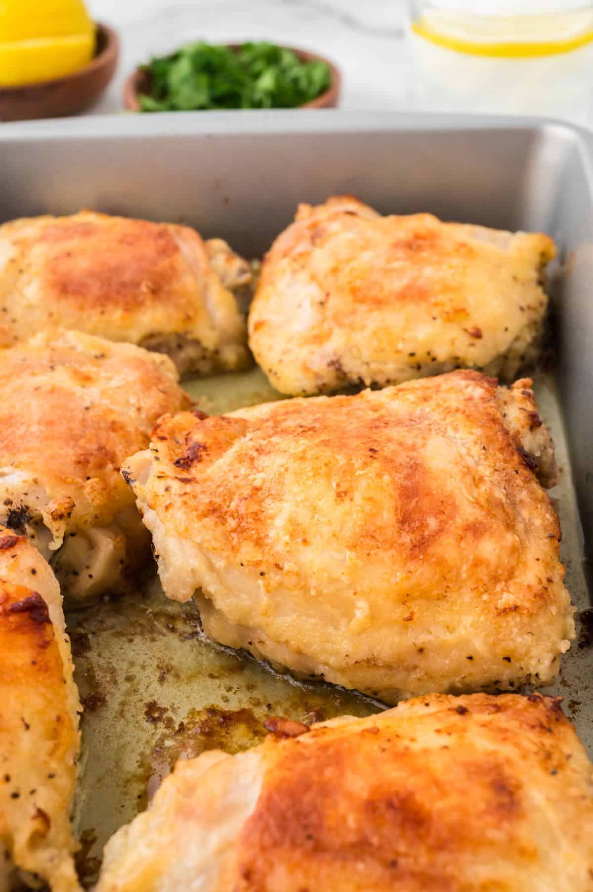 Oven-fried Chicken thighs in a baking pan.