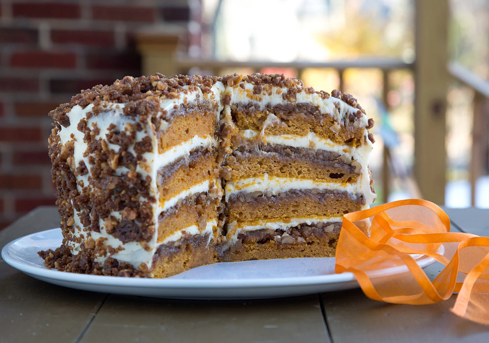 A four layer pumpkin crunch cake with several slices cut out. 